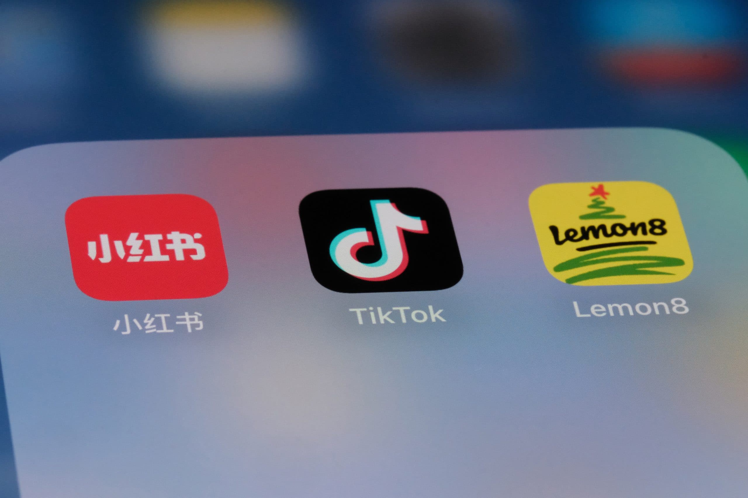 FMCG supply chain adaptation to social commerce: Close-up of smartphone screen showing app icons for Xiaohongshu (Little Red Book), TikTok, and Lemon8, representing major platforms driving change in Asian retail and logistics.